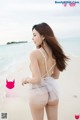 A woman in a white dress standing on a beach.